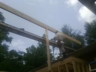 Carpenter setting a ridge beam over a new addition frame — Ice Dam Removal by Roofing Brothers in Cross River