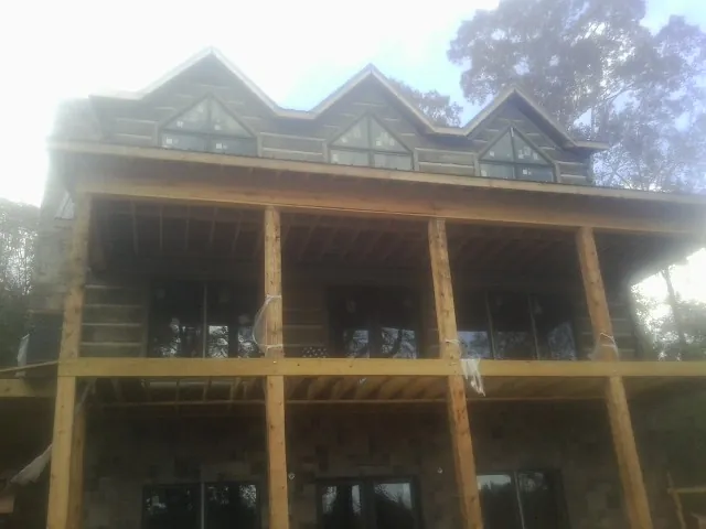 Dormers and porch framing on a large log home under construction — Roof Coating work by our crew in Cross River