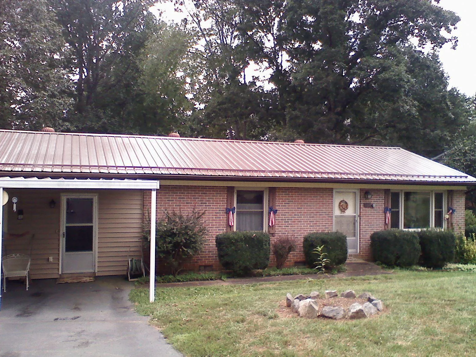 Bronze metal roof and carport on a brick ranch home — Roof Repair work by our crew in Cross River